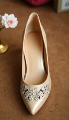 Elegance in Essence A beige high-heeled shoe adorned with delicate floral embellishments, complemented by a charming white flower that whispers of grace and beauty.