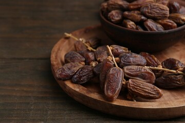 Tasty dried dates on wooden table, closeup. Space for text