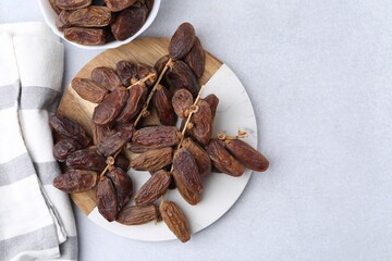 Tasty dried dates on light table, top view
