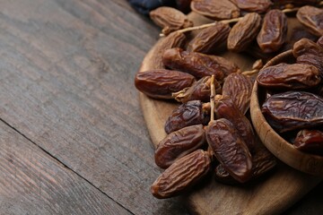 Tasty dried dates on wooden table, closeup. Space for text