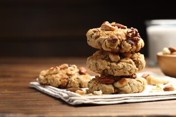Tasty cookies with nuts on wooden table, closeup. Space for text