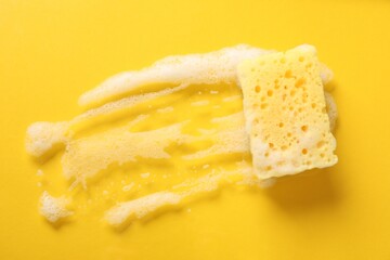 One cleaning sponge and foam on yellow background, top view. Space for text