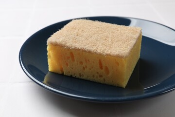 Sponge and plate on white tiled table, closeup