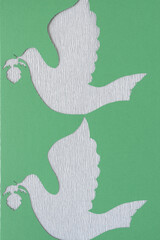 stencil of holiday birds of peace machine-cut from green paper