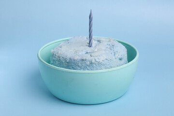 blue bento cake in a bowl with a candle