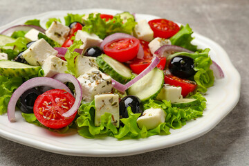 Delicious salad with feta cheese on gray textured table, closeup
