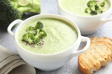 Delicious broccoli cream soup served on light table, closeup