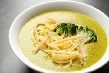 Delicious broccoli cream soup in bowl on gray table, closeup