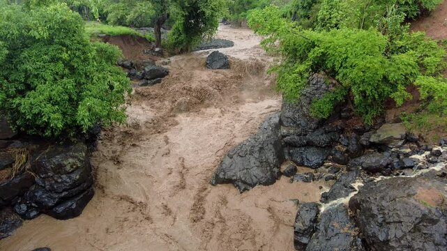 Raging muddy flood waters flowing down a river in Southern Ethiopia near Konso
