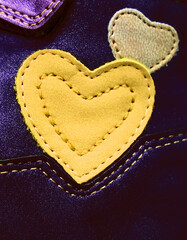 Leather patches, accessories in the shape of hearts on dark. Repairing hole in textile