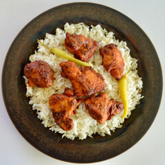Tikka masala chicken pieces on a bed of long grain white rice.