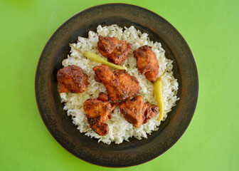 Tikka masala chicken pieces on a bed of long grain white rice.