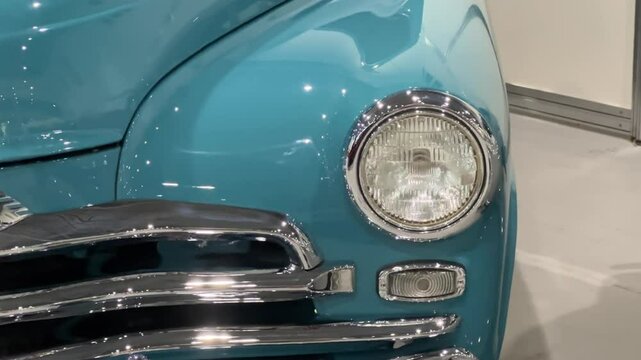 Vintage Soviet luxury car headlight and chrome grille detail, classic 1950s automobile in turquoise blue color, retro vehicle front view