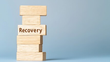 Recession unemployment concept. Stacked wooden blocks with the word "Recovery" emphasize building resilience and healing processes.