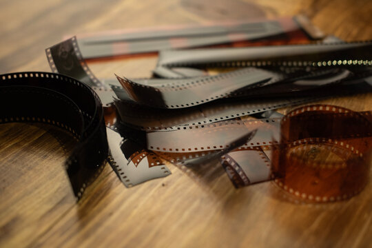 Rollo fotogr&aacute;fico, fotograf&iacute;a anal&oacute;gica, pel&iacute;cula de 35mm sobre la mesa, negativos, retro, vintage, film, acercamiento