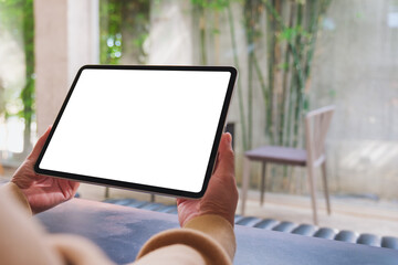 Mockup image of a woman holding digital tablet with blank desktop screen in cafe