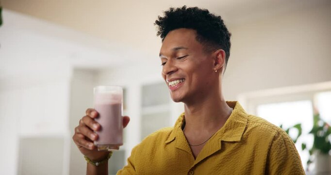Home, man and happy with glass of smoothie in kitchen for diet, nutrition and healthy food. Apartment, male person and smile with milkshake or organic drink with vitamins and ingredient for wellness