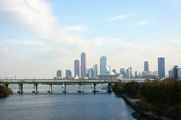 Naklejka premium A skyline of Yeouido, Seoul, Korea with modern skyscrapers and a bridge over a river.
