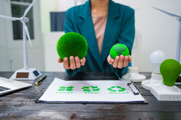 A businesswoman sits at a desk discussing the Earth, environment, renewable energy, and...