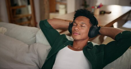Man, headphones and relief on couch in home with audio streaming, chill and break on weekend in lounge. Person, music and listening to song, eyes closed and reflection in living room at apartment