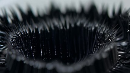 Slow motion video follows ferrofluid texture with dynamic spikes and ambient light revealing formations - Powered by Adobe