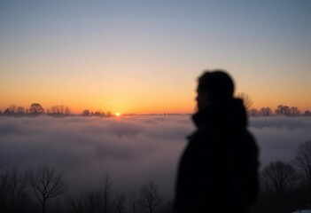 Fototapeta premium A silhouette of a sunrise breaking through winter fog 