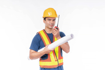 Male construction worker wearing safety helmet and reflective vest, holding a rolled blueprint and walkie-talkie, standing confidently, isolated on white background