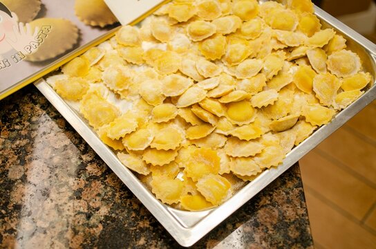 Marubini, traditional stuffed pasta from cremona, italy, resting on metal tray