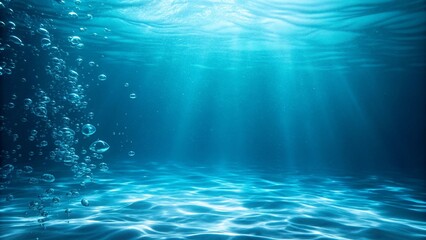 An underwater scene where sunlight streams through the water, creating a tranquil atmosphere over sandy ocean floor.