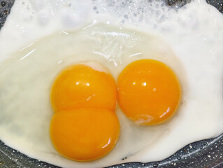 Fried eggs with three yolks in one egg in a frying pan