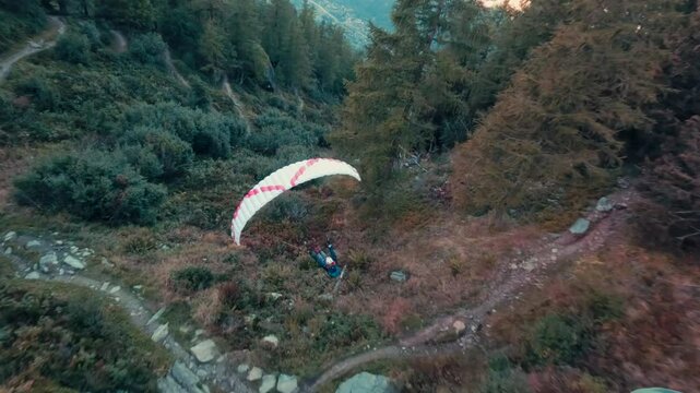 An extreme paragliding pilot flying near a majestic mountain, showcasing breathtaking aerial views of the surrounding landscape.