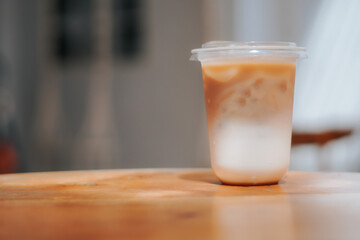 A refreshing glass of iced coffee sits on a wooden table, perfect for a sunny day. The image captures the drink's cool, refreshing appeal, perfect for cafes, food blogs, and lifestyle content.
