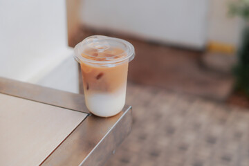 A refreshing glass of iced coffee sits on a wooden table, perfect for a sunny day. The image captures the drink's cool, refreshing appeal, perfect for cafes, food blogs, and lifestyle content.
