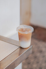 A refreshing glass of iced coffee sits on a wooden table, perfect for a sunny day. The image captures the drink's cool, refreshing appeal, perfect for cafes, food blogs, and lifestyle content.