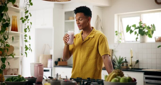 Home, man and smile with glass of smoothie in kitchen for diet, nutrition and healthy food. Apartment, male person and happy with milkshake or organic drink with vitamins and ingredient for wellness