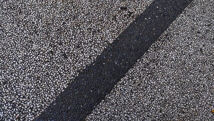 Fototapeta premium Close-Up of Textured Road Surface with Dark Stripe Detail