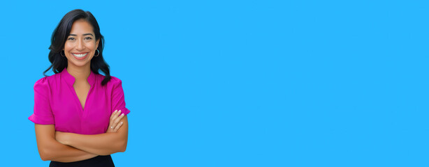 Confident woman in bright pink blouse smiling with arms crossed against a bright blue background, providing ample copy space for text or design elements, ideal for business or promotional use.