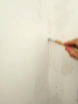 Gros plan d'une personne peignant un mur avec un pinceau