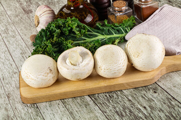 White champignon mushrooms heap over board