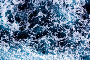 Ocean surface background. Top view of breathtaking foamy water. Can be used in covers, packaging, posters, textures, wallpapers, art and design projects. Elegant nature background image.