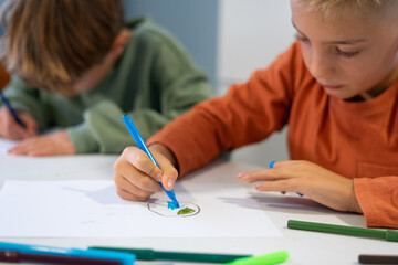 Elementary school student drawing with markers in art class