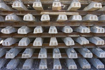 Rusty intermediate rail fasteners on concrete sleepers for train and tram, laying railroad tracks