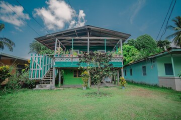 Typical houses at Bocas del Toro island consist. wooden house with colorful flowers on the balcony and stairs leading up. All in white turquoise setting.