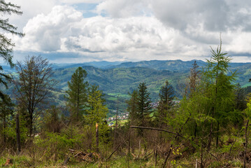Obraz premium Klubina villlage wiith hills of Kysucke Beskydy mountains from hiking tral between sedlo Korchan and Hladky vrch in Kysucka vrchovina mountains in Slovakia