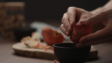 man peeling pomegranate close up