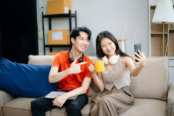 Young couple organizing belongings in a cozy home with boxes and luggage. Perfect for themes of moving