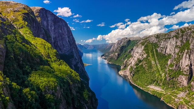 Kjerag, Lysefhjorden, Norway, A panoramic view of a fjord in Norway, featuring towering cliffs, lush greenery, and a calm, blue body of water - Powered by Adobe
