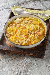 Egg Roll Soupp  basically an Asian cabbage soup, simmered with zesty sausage, carrots, sesame and ginger closeup on the baking dish on the table. Vertical