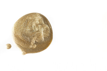 Round gold shimmering nail polish swatch on white background, ideal for beauty and makeup marketing.