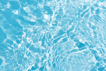 Blue water with ripples on the surface. Defocus blurred transparent blue colored clear calm water surface texture with splashes and bubbles. Water waves with shining pattern texture background.